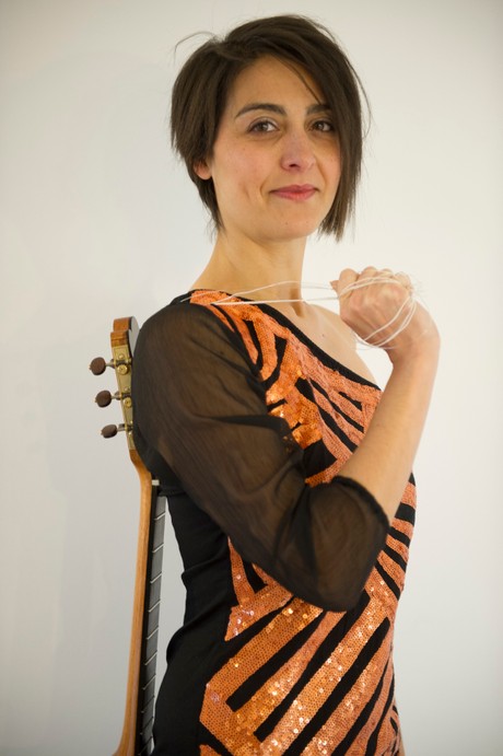 Cinzia Milani smiling with guitar slung over shoulder